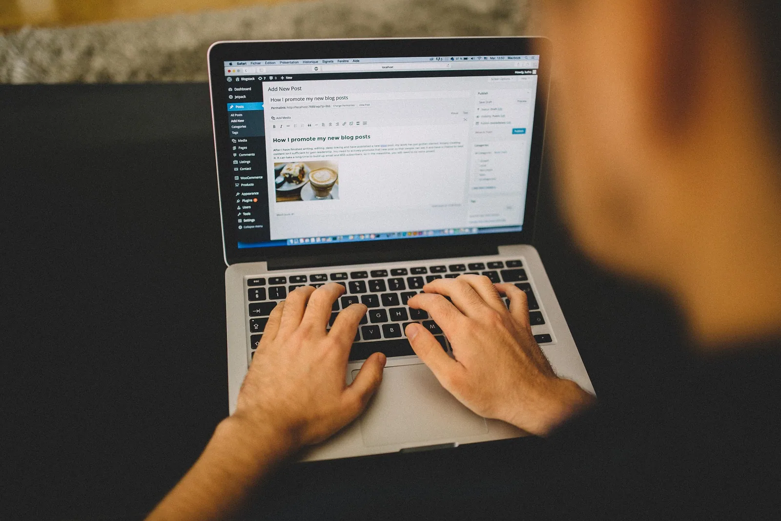 Hands typing on a laptop showing the WordPress Add New Post editor